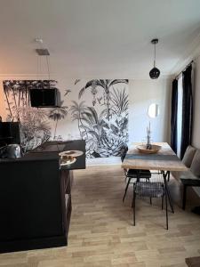 a living room with a table and a kitchen at Appartement de caractère in Épinal