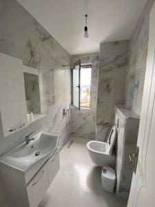 a white bathroom with a sink and a toilet at Sempaola Borsh Apartments in Borsh +30 photos