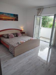 a bedroom with a bed and a sliding glass door at Apartment Valeria in Lopar