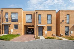 un bâtiment en briques avec une voiture garée dans l'allée dans l'établissement Cozen, à Stone Grove