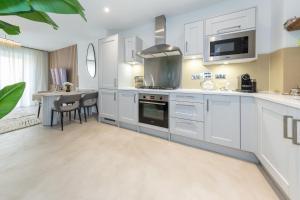 a kitchen with white cabinets and a dining room at Cozen in Stone Grove