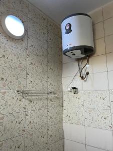 a bathroom with a shower with a toilet and a light at Résidences PRIMIS Thiès - appartements et chambres in Thiès