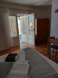 Un dormitorio con una gran cama blanca y una mesa en Apartments Rako, en Brela