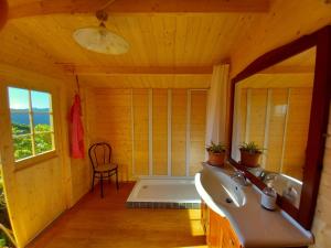a bathroom with a sink and a window and a chair at Glamping tent nel Supramonte in Urzulei