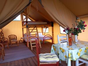 Una habitación con una mesa y una cama en una tienda de campaña en Glamping tent nel Supramonte, en Urzulei