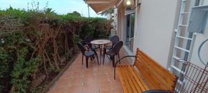 un patio con mesa, sillas y banco en Apartamento Cala Montero I, en Vinarós