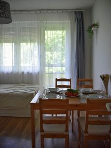 a dining room with a table and chairs and a bed at Helikon 32 Apartman Keszthely in Keszthely