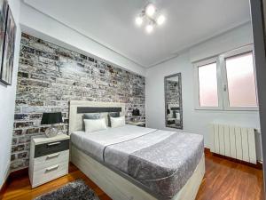a bedroom with a brick wall and a bed at Apartamento coqueto gran Bilbao in Basauri