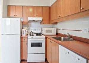 a kitchen with a white refrigerator and a sink at 1BD+Den condo, with free parking in Downtown! in Vancouver