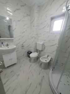 Baño blanco con aseo y lavamanos en CAZARE EDI en Corbu