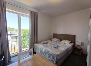 a bedroom with a bed and a large window at Firstroom Gdańsk in Gdańsk