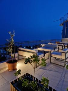 a rooftop patio with tables and benches at night at Adriatic Apartments in Ulcinj