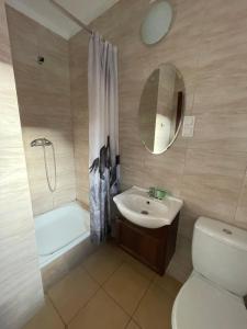 ein Badezimmer mit einem Waschbecken, einem WC und einem Spiegel in der Unterkunft Villa Dolce Vita in Mrzeżyno