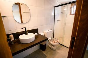 bagno con lavandino, servizi igienici e specchio di Horizonte Azul Noronha a Fernando de Noronha