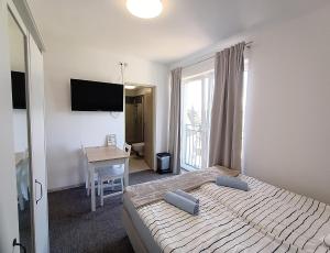 a bedroom with a bed and a desk and a television at Firstroom Gdańsk in Gdańsk
