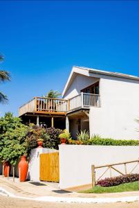 Cette maison blanche dispose d'un balcon. dans l'établissement Horizonte Azul Noronha, à Fernando de Noronha