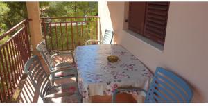 a table and chairs sitting on a balcony at Apartmani Kerum in Jelsa