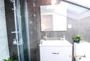 W łazience znajduje się prysznic, umywalka i lustro. w obiekcie Apartment with views of the Cathedral w Santiago de Compostela