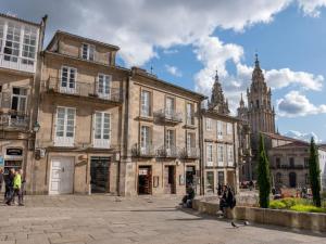 grupa budynków w mieście z wieżą zegarową w obiekcie Apartment with views of the Cathedral w Santiago de Compostela