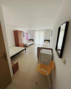 a room with two beds and a table and a chair at Villa Djekovic in Čanj