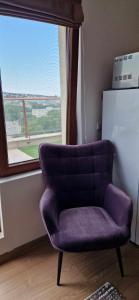 a purple chair in a room with a window at Студио Тони 2 in Varna City