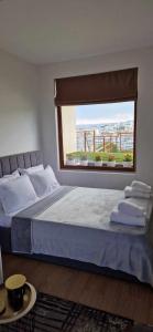 a bedroom with a large bed with a large window at Студио Тони 2 in Varna City