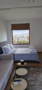 a bedroom with a bed and a couch and a window at Студио Тони 2 in Varna City
