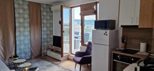a kitchen with a refrigerator and a large window at Студио Тони 2 с панорамна тераса и морска гледка Варна in Varna City