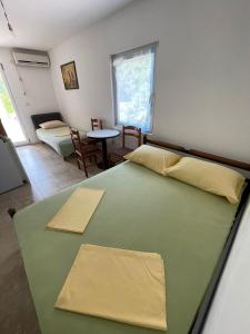 a bedroom with two beds and a table in it at Villa Djekovic in Čanj