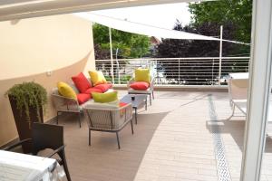 un patio con divani e sedie su un balcone di Il Terrazzo 40 metri dal mare a Giulianova
