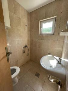 a bathroom with a sink and a toilet and a window at Villa Djekovic in Čanj