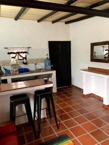 - une cuisine avec un comptoir et des tabourets dans une pièce dans l'établissement Cabaña en la Montaña, 2 Habitaciones, à Sutatausa