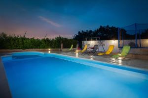 een zwembad met stoelen eromheen bij Holiday Residence Maja in Katuni