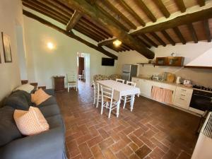 a living room with a table and a kitchen at Agriturismo La Peschiera in Casole dʼElsa