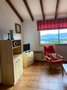 - un salon avec une chaise rouge et une fenêtre dans l'établissement Appartement Marina di santa giulia, à Porto-Vecchio
