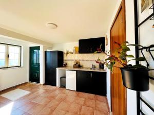 a kitchen with black cabinets and a tile floor at Quinta Alma Verde 