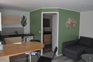 uma cozinha e sala de estar com uma mesa e um sofá em Ailleurs Land - Provence em Néoules
