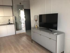 a living room with a flat screen tv on a dresser at Comfort18 in Bydgoszcz