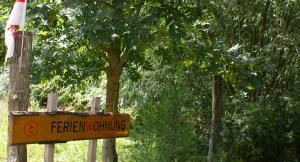 um sinal em frente a uma árvore numa floresta em Ferienwohnung Fuchsberge em Letschin