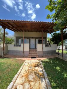 a house with a wooden pavilion in a yard at Cozy House in Lagonisi in Áyios Nikólaos