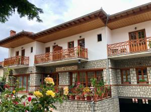 un edificio con balcones y flores delante de él en Apostolos Hotel en Metsovo