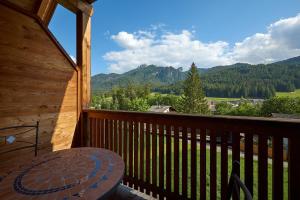 a balcony with a table and a view of the mountains at Garni Appartments Helvetia in Villabassa