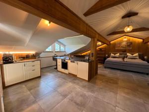 - une cuisine avec des placards blancs et un lit dans une chambre dans l'établissement Bauernhof-Loft Edtgut, à Guggenthal