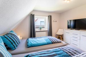 Schlafzimmer mit einem Bett und einem Flachbild-TV in der Unterkunft Haus Hamburg Wohnung 2 in Hohwacht