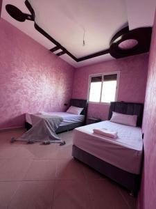 twee bedden in een kamer met roze muren bij apartment in Agadir 10 minutes from the beach in Agadir