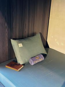 a bed with a pillow and a book and a wallet at T Zone Hostel in Ho Chi Minh City