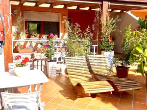 una panca di legno seduta su un patio con piante in vaso di Casa mare Golfo di Cagliari a Su Forti