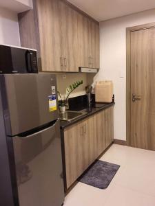 a kitchen with a stainless steel refrigerator and a sink at A home away from home. in Manila