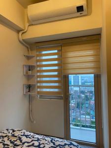 a bedroom with a window with a blind at A home away from home. in Manila