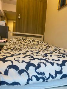 a bed with a blue and white comforter on it at A home away from home. in Manila